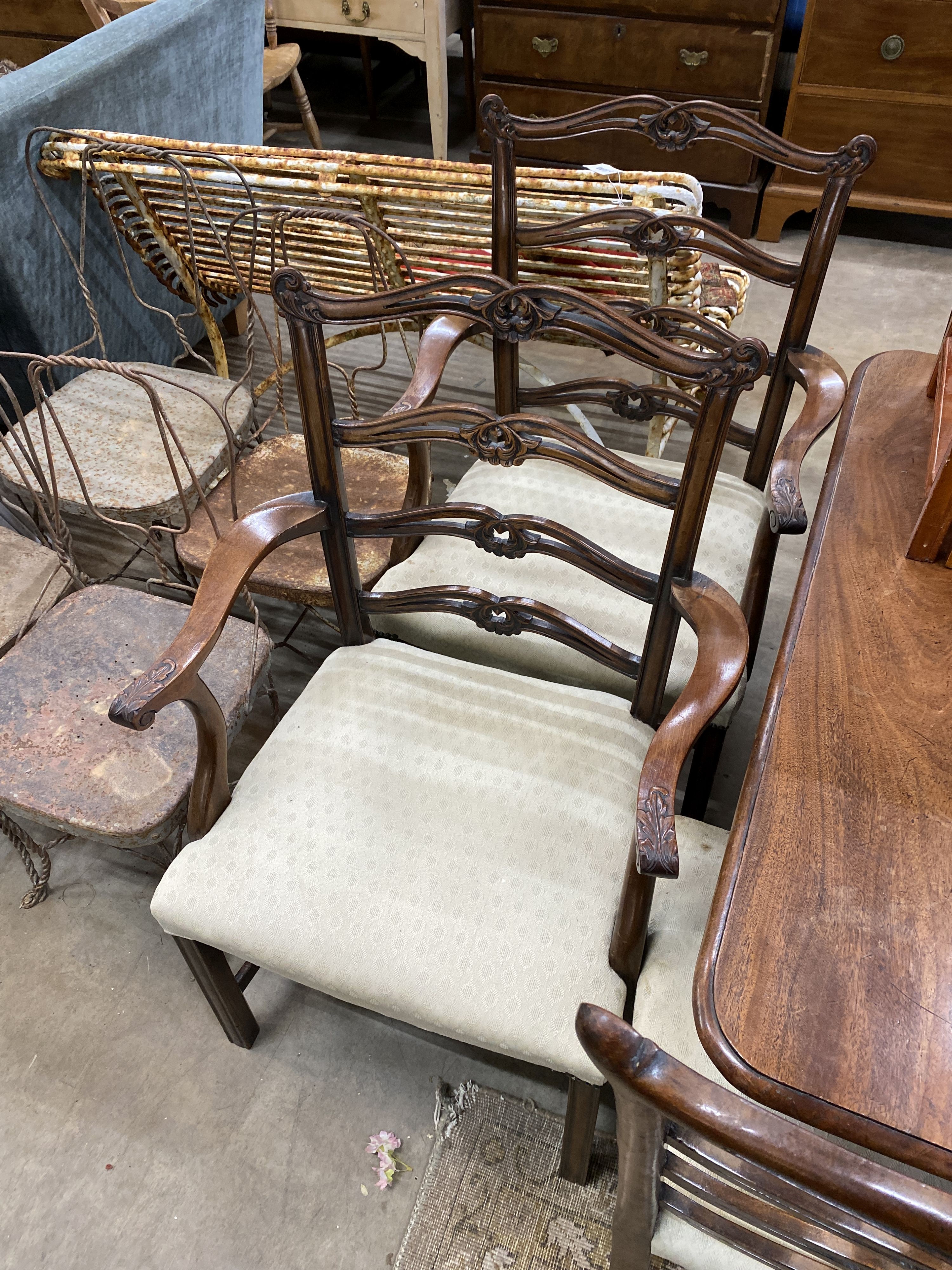 A set of eight Chippendale style mahogany dining chairs with pierced ladder backs, two with arms